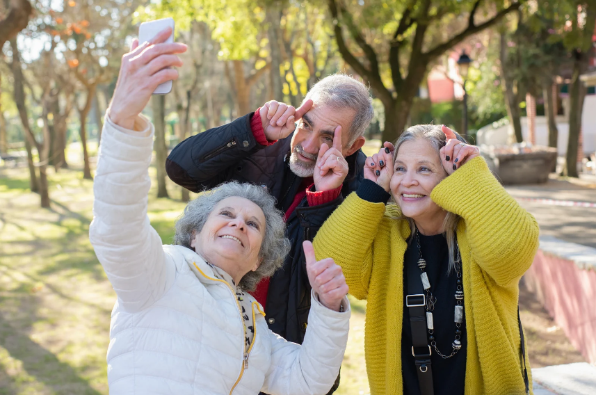 un groupe de personnes avec cheveux gris (2 femmes et un homme) en train de faire des grimaces pour un selfie